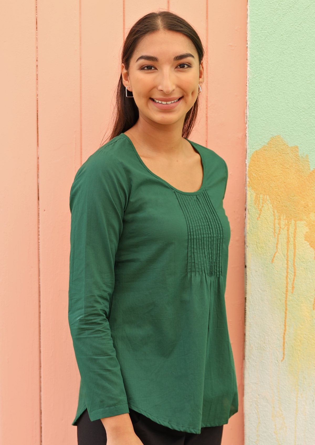 Model wears green long sleeve cotton top with round neckline