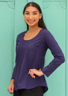 Model wears blue long sleeve cotton top with round neckline