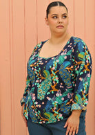 plus sized model wearing bright coloured long sleeve cotton blouse with scoop neck 