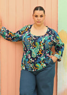 plus sized model wearing bright coloured long sleeve cotton top with scoop neck 