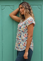 Model wears a floral top with elastic trim in the short sleeves. 