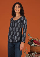  Model with dark hair in blouse with floral motif and scoop neck