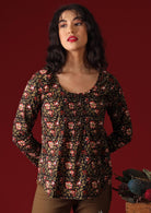 Model with dark hair wearing long sleeve scoop neck cotton women's blouse