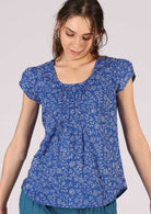 Model pairs loose fit 100% cotton top with blue pants.