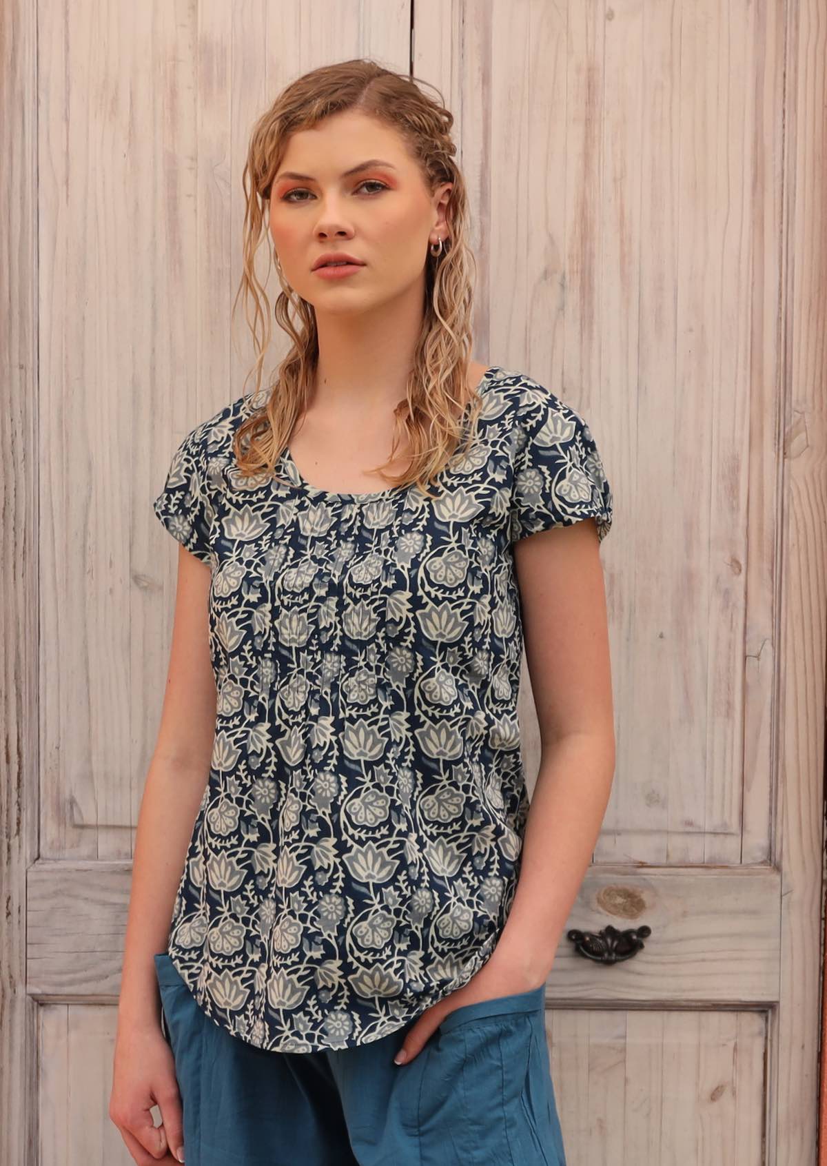 Model wears a blue based cotton top with a white floral print.