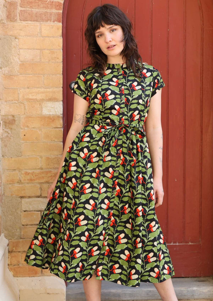Model wears Vivien Dress Oak green black cotton 50's style button through midi dress with mandarin collar, belt loops, waist tie, and hidden side pockets | Karma East Australia