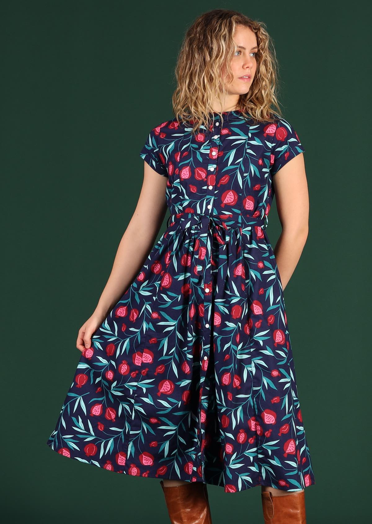 Model wears a blue pomegranate print dress with waist tie