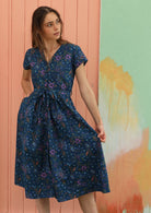 Model holds out the skirt of her retro style cotton dress. 