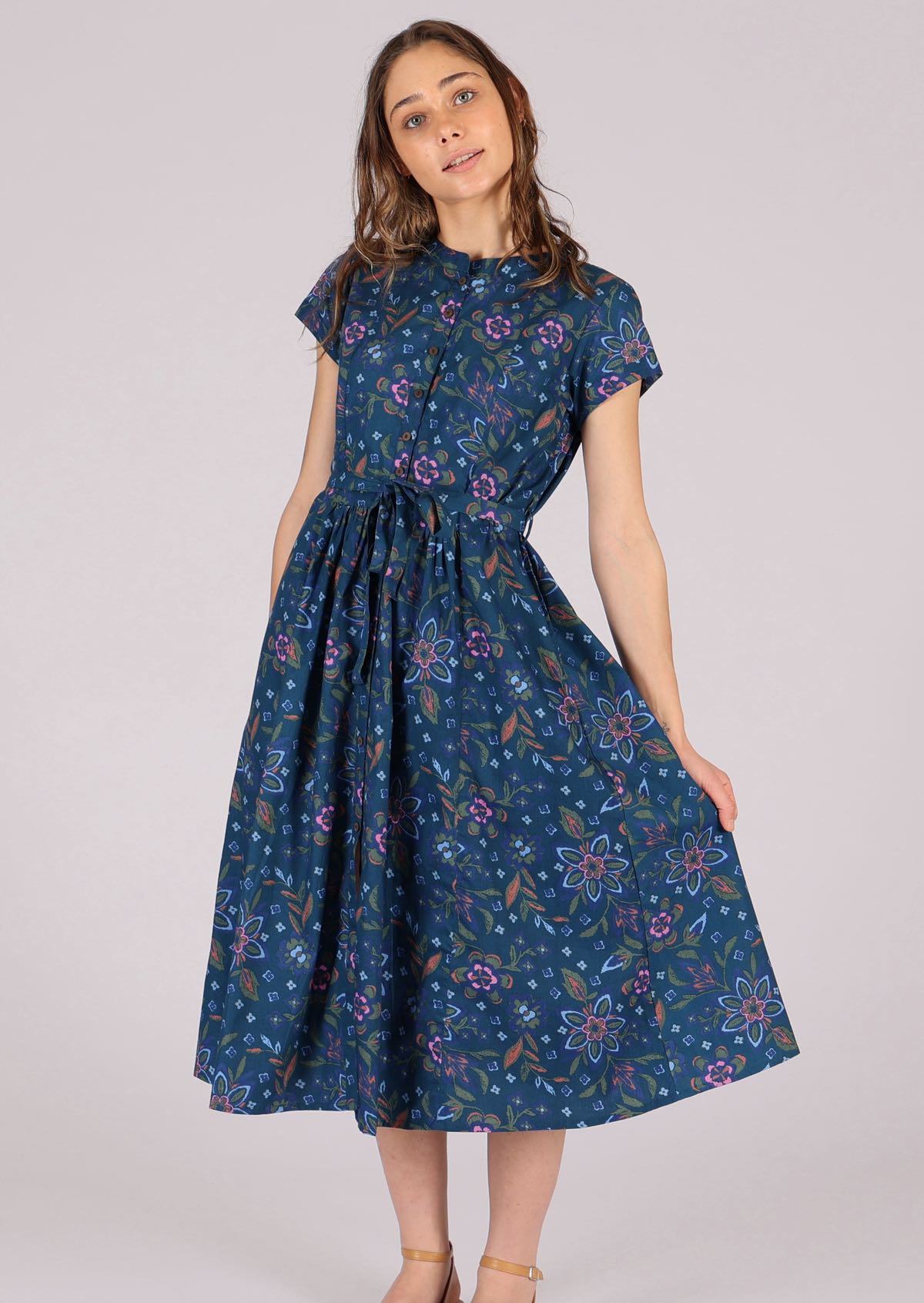 Model wears retro style cotton dress with pleats at the waist. 