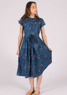 100% cotton blue based dress is styled with brown sandals. 