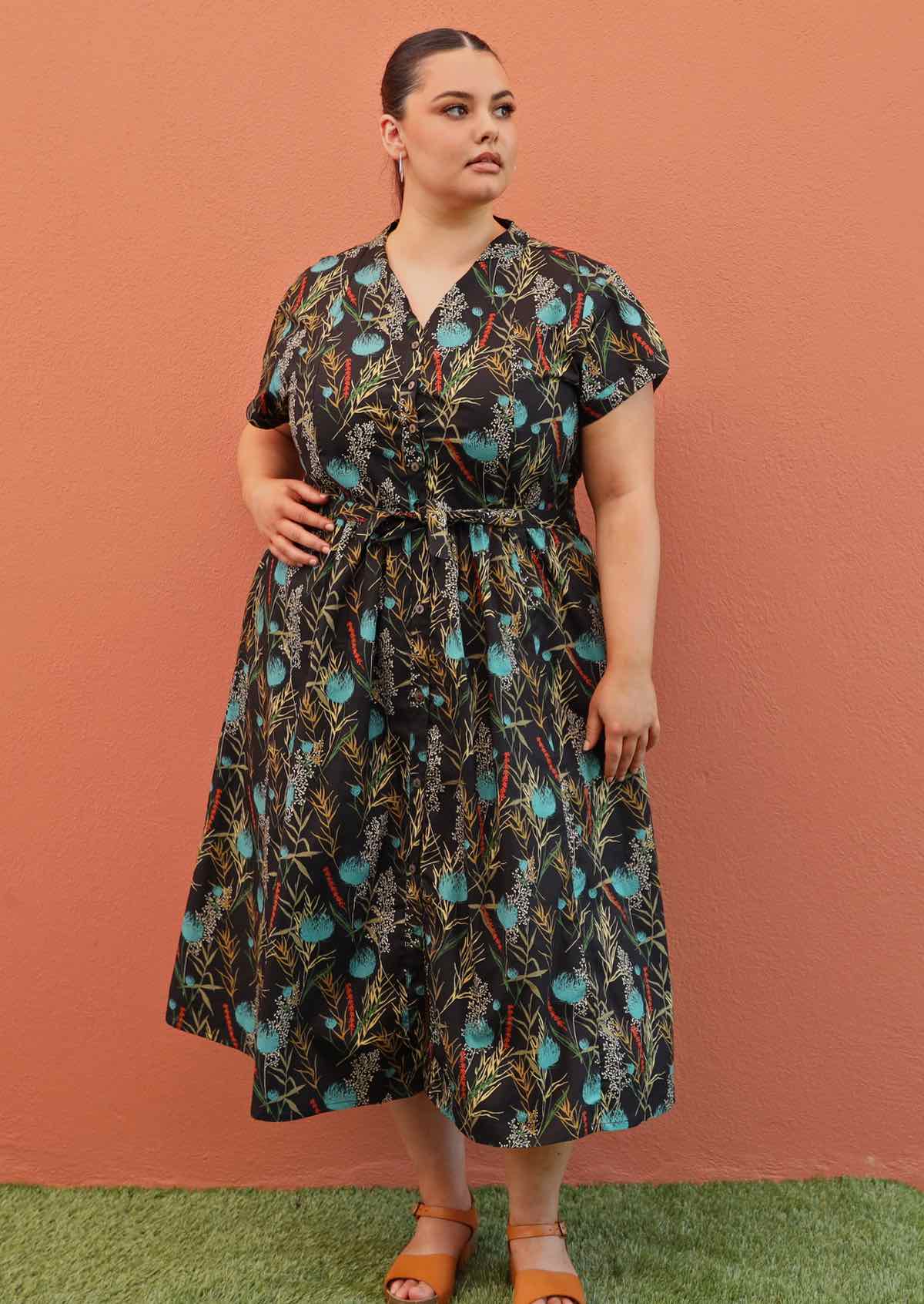 Plus size model wearing Vivien dress in black and teal with pockets and v neck line
