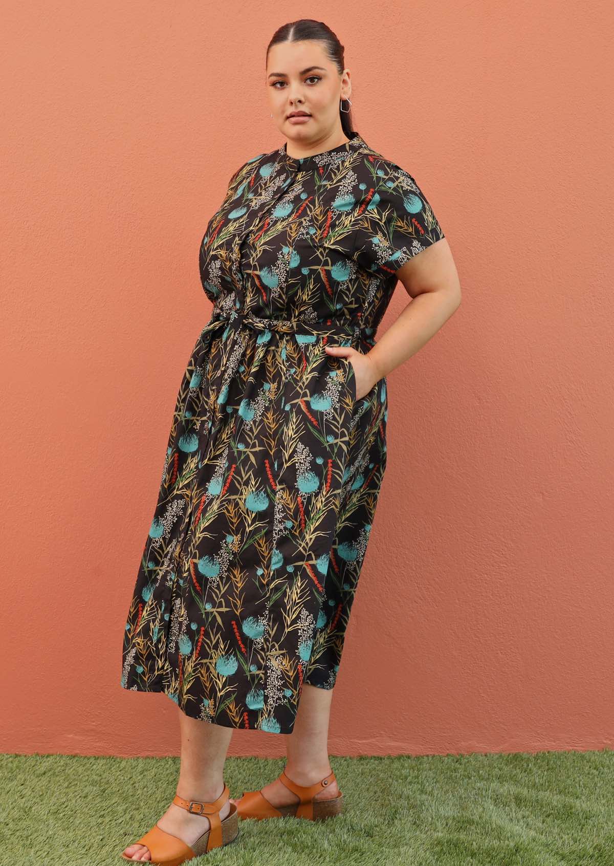 Plus size model wearing Vivien dress in black and teal with pockets and mandarin collar