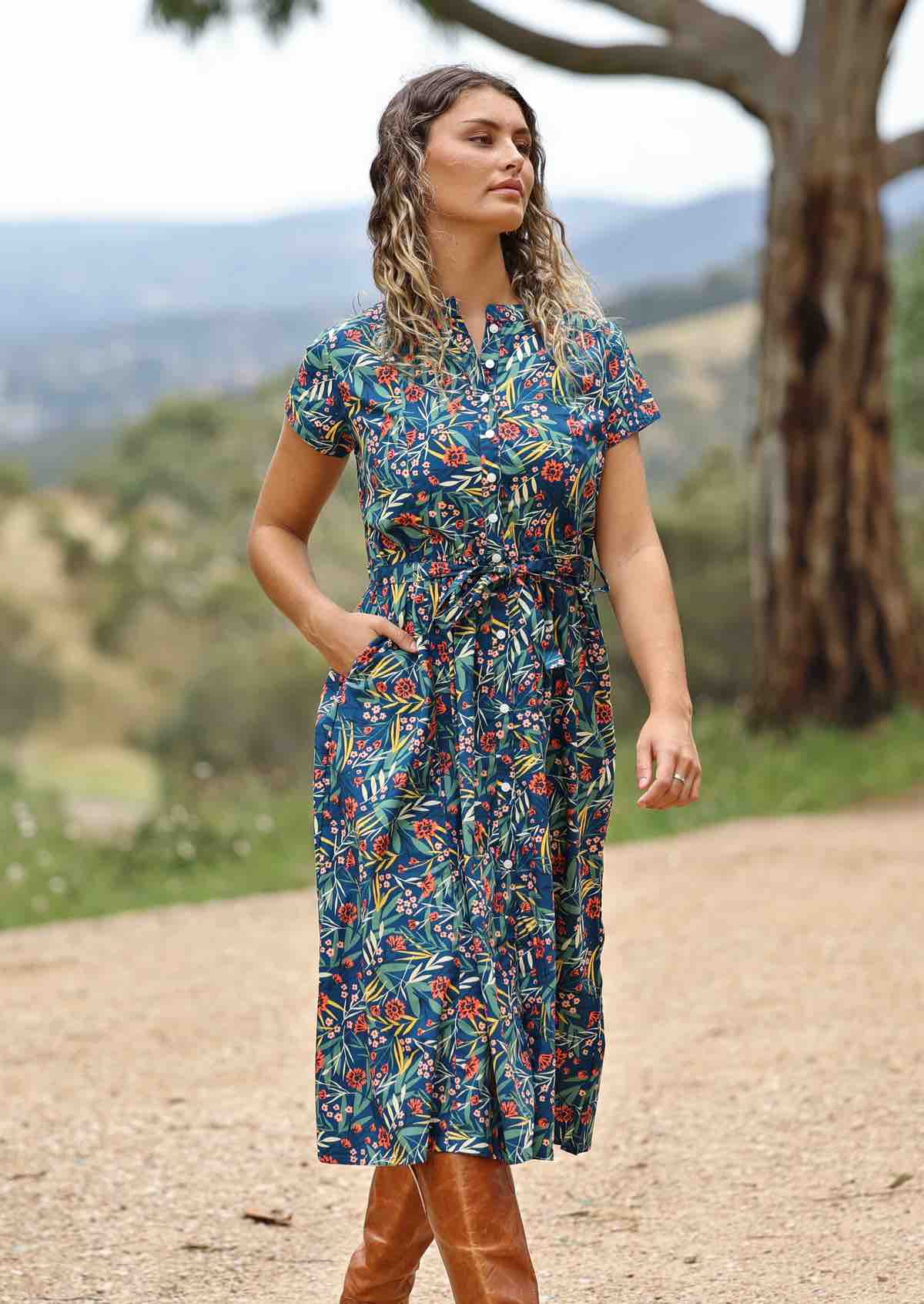 woman wearing floral button up retro style maxi dress with hand in pocket