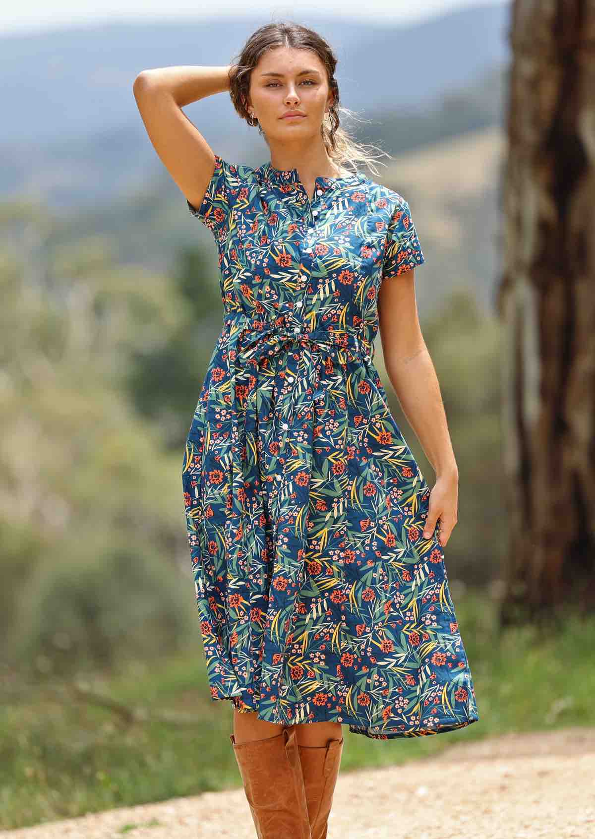 woman wearing floral button up retro style maxi dress trees background