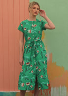 Model wears green dress with a floral print. 