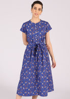 Model wears cotton short sleeve retro dress with a blue and white floral print. 