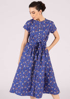 Model wears retro style blue and floral dress made from 100% cotton. 