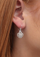 Closeup of silver celtic knot earring on hook