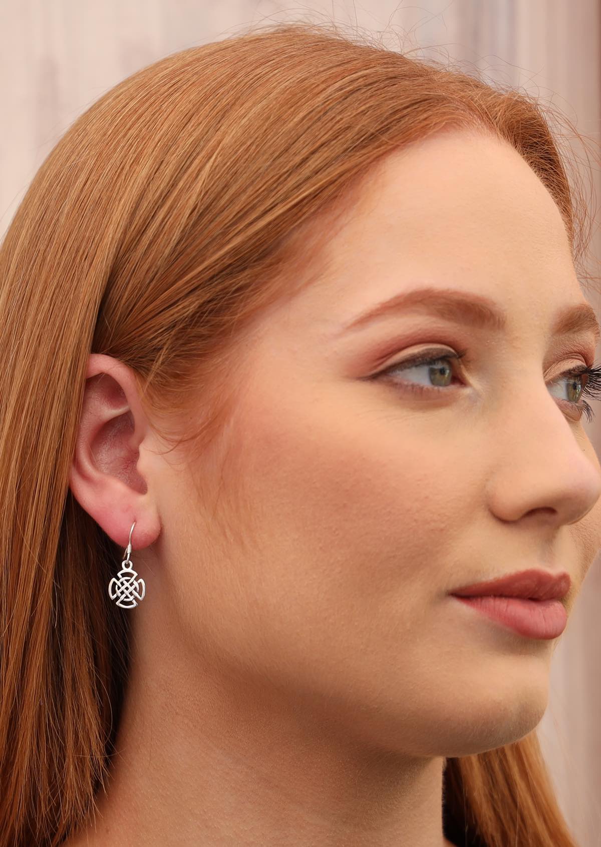 Model wears sterling silver celtic woven knot earring on hook