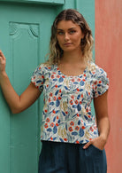 Model wears cotton top with cap sleeves and round neckline