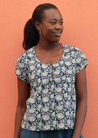 Model wears cotton top with a scooped neckline. 