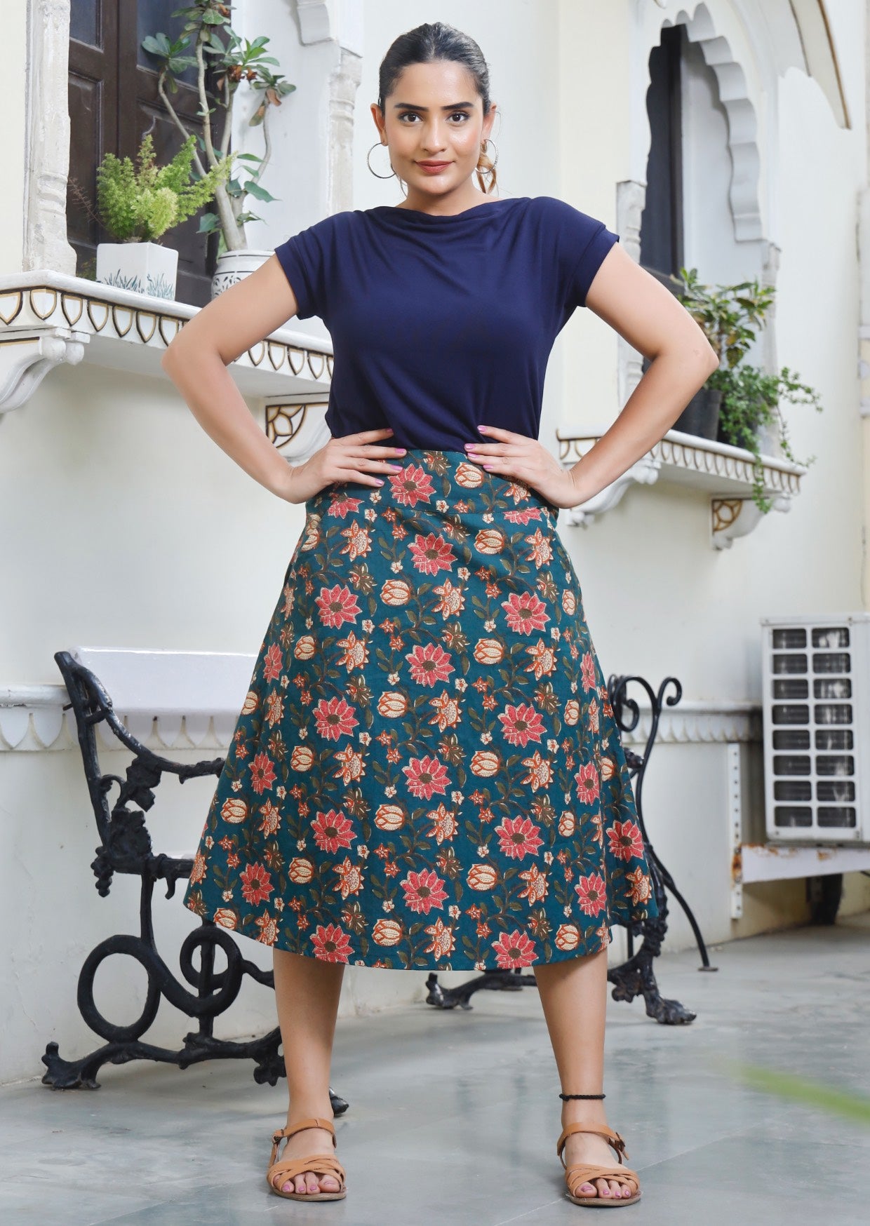 Woman wears knee length A line skirt in gorgeous green based floral print 