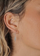 Lightning Bolt Dangly Silver Earrings on woman's ear