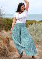 Model holding pant wears rayon wide legged womens palazzo pant with elastic waist