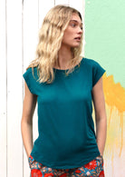 Woman wearing a soft flattering fit teal rayon jersey t-shirt.