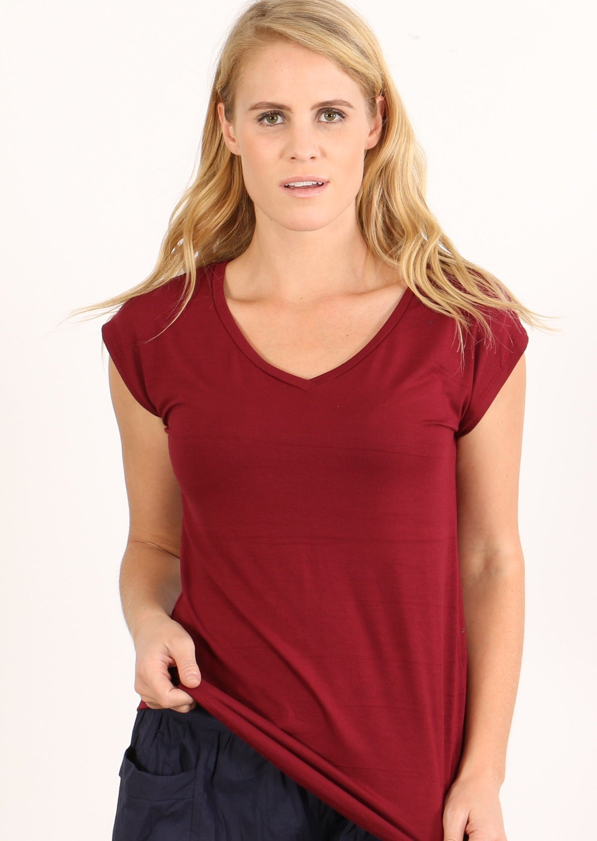 Woman with blonde hair wearing a maroon v-neck short cap sleeve rayon top