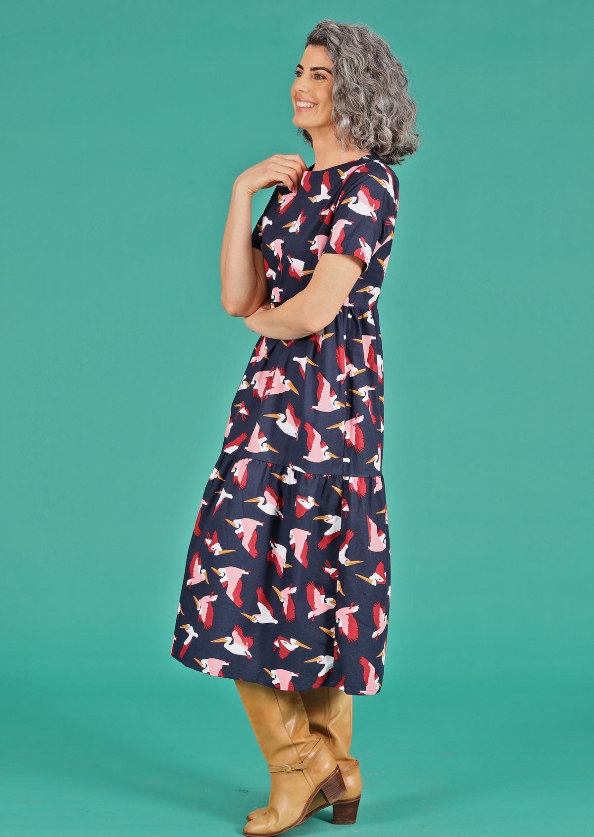 Side view of woman wearing round neck cotton dress with hidden pockets