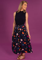Woman wears cotton button through skirt with Box pleats and pockets.