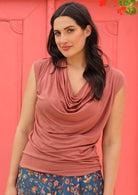 Woman wearing dusty rose cap sleeve loose rayon cowl neck top