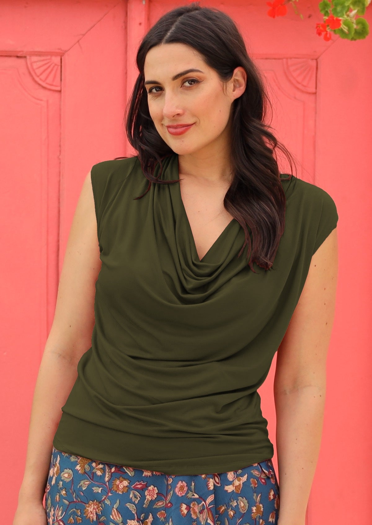 Woman wearing a cowl neck rayon olive cap sleeve top.
