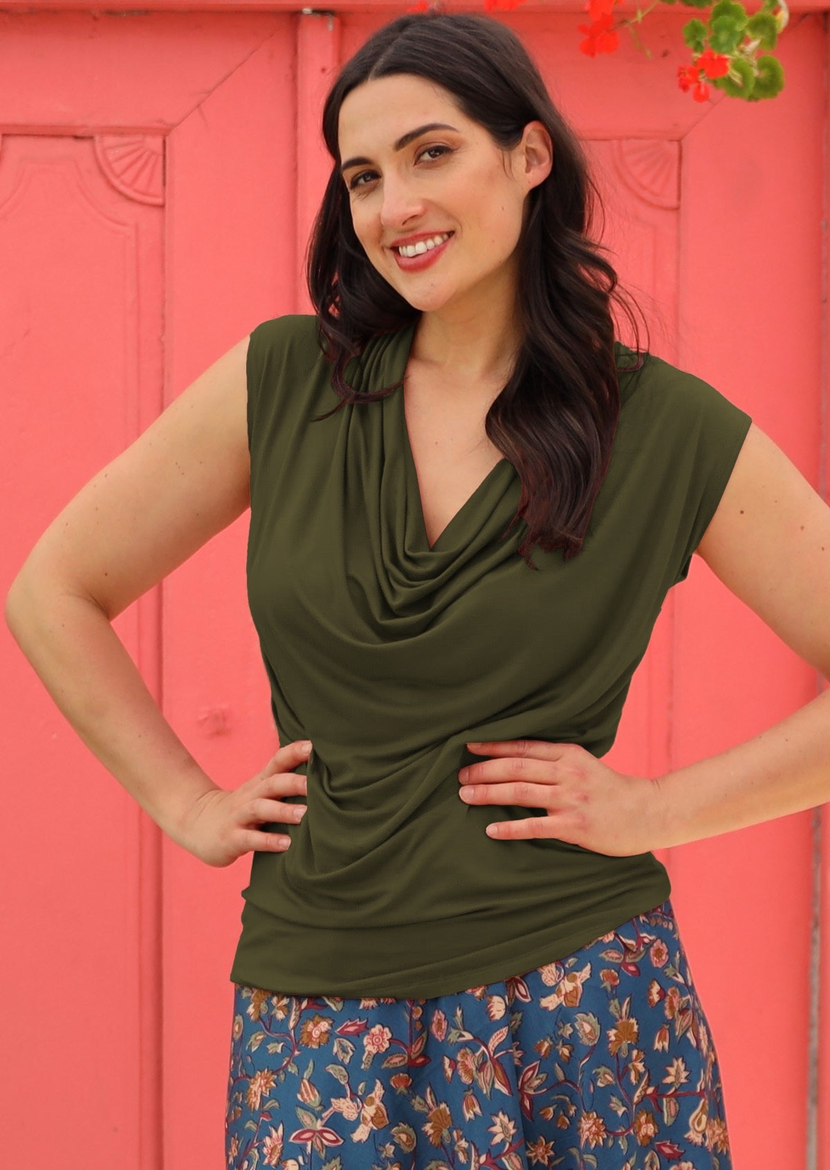 Woman with hands on hips wearing a cowl neck rayon olive cap sleeve top.