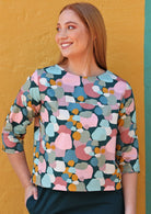 Woman wears cotton pastel coloured relaxed fit top with high round neckline and 3/4 sleeves