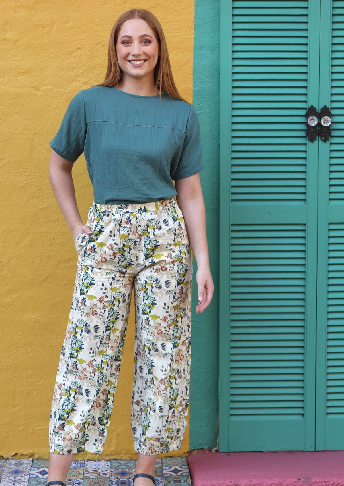 Greta Pants high waisted women's pants elasticated waistband side pockets pleats at side of ankles 100% cotton off white background with green and nude toned floral | Karma East Australia