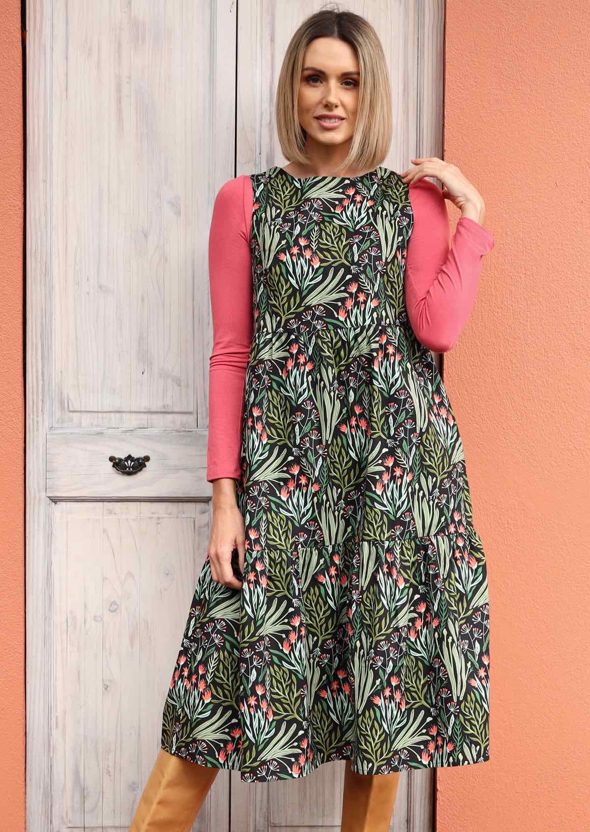 woman wearing cotton sleeveless 3 tiered dress with green floral print 