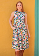 Red haired model wearing high neck dress with pastel spots with hand in pocket.