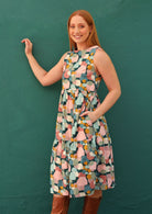 Woman wearing tiered midi dress with high round neckline and pockets 