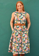 Model wearing sleeveless dress with pastel patches design with pockets.