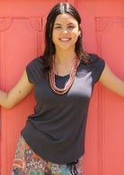 Woman wearing a dark grey v-neck short cap sleeve rayon top