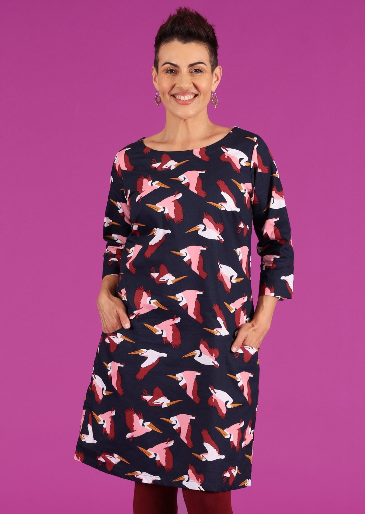 Jamie Dress round neck 3/4 sleeve cuff detail fitted bodice a-line skirt pockets knee length 100% cotton navy background maroon pink and white pelican print | Karma East Australia