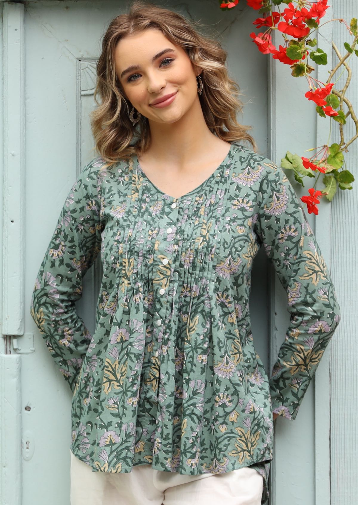 Leia Blouse slight v-neck pleats front and back, button down front long sleeve loose fit a-line flare hem longer at back 100% cotton sage green background | Karma East Australia