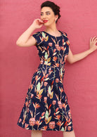 Woman wears round neck 100% cotton knee length dress with cap sleeves and pockets