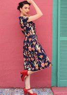 Ove the Knee Length Botanic Floral Printed Cotton Dress with a blue base, paired with red heels