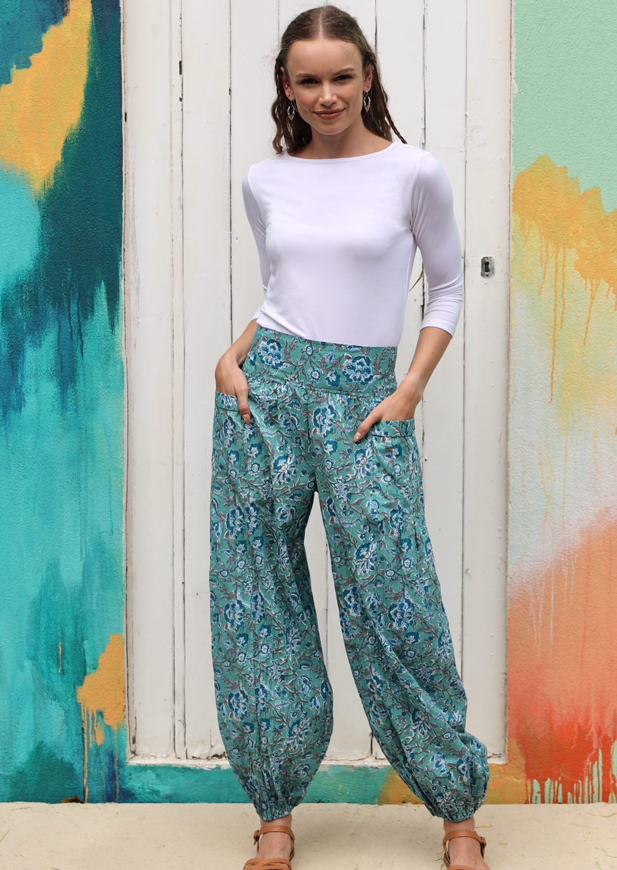 Model pairs blue floral cotton pants with white long sleeve basic top 