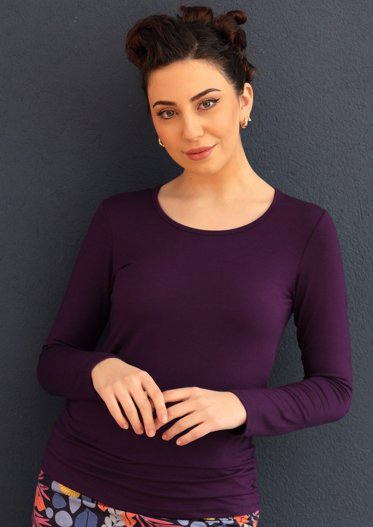 Woman wearing a round neck purple long sleeve rayon top.