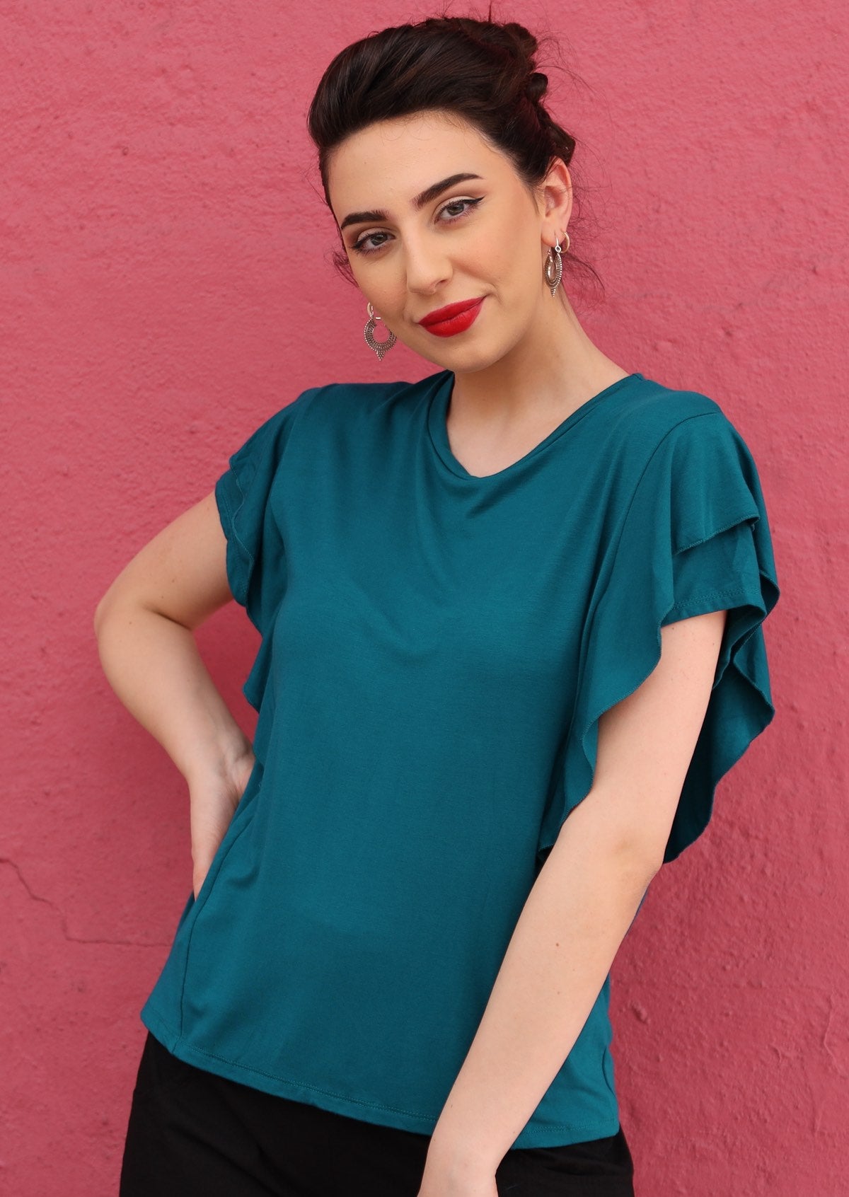 Woman wearing a teal ruffle rayon top.