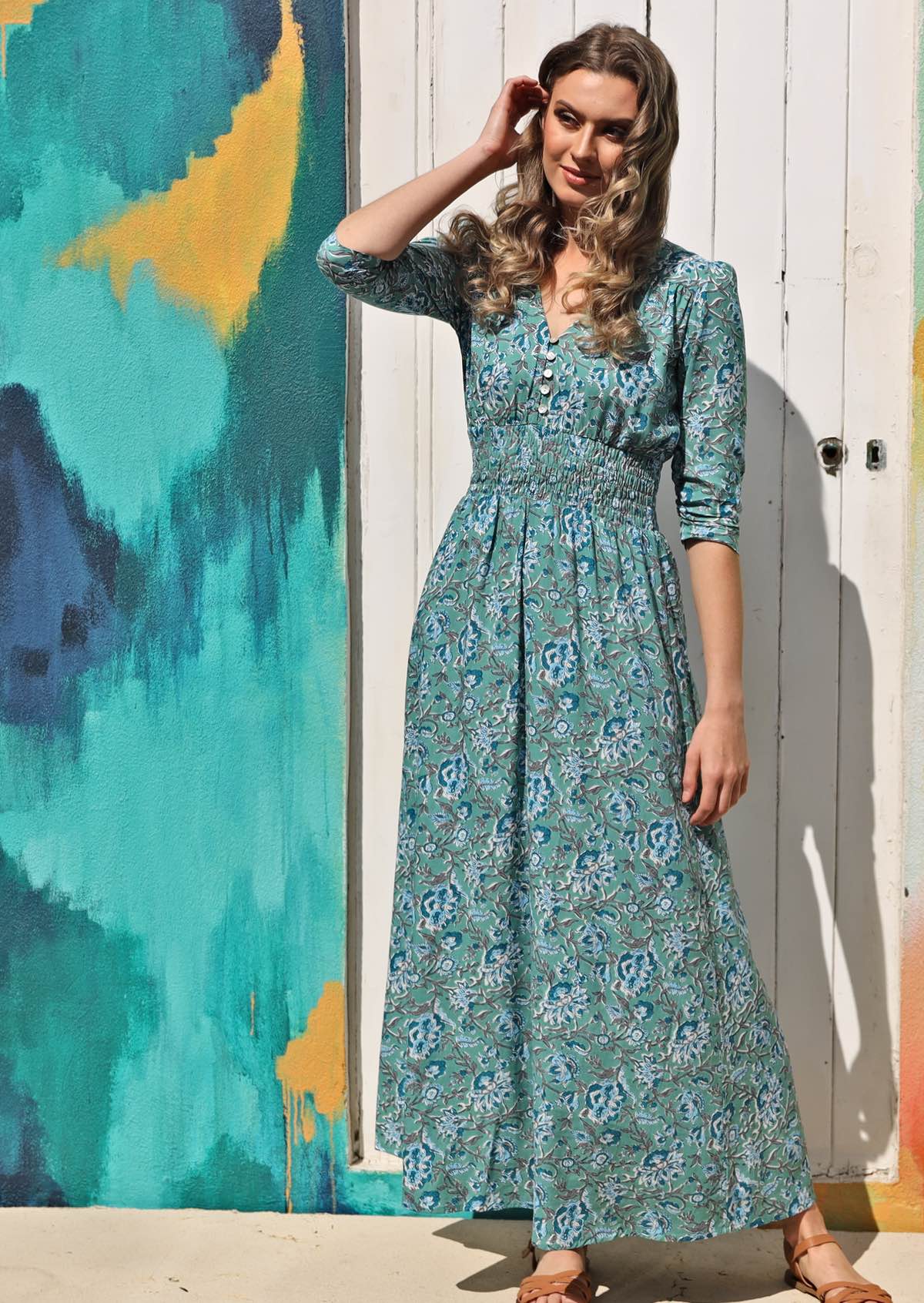 Model wears floaty rayon maxi dress with buttoned bodice, V-neckline, 3/4 sleeves and ruched waistband.